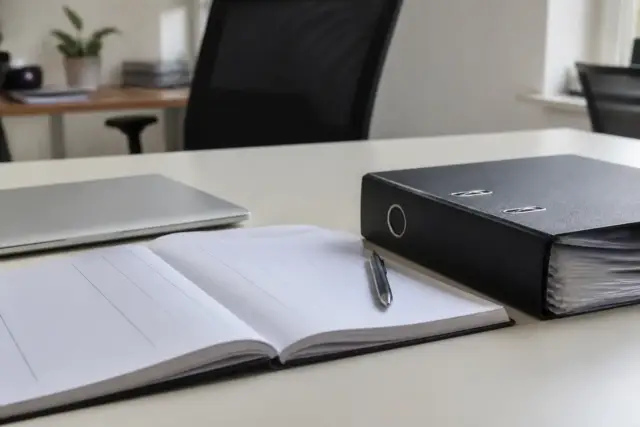 Registre du personnel ouvert sur un bureau, une ligne de salarié avec dates d’entrée et de sortie, stylo et classeur à côté