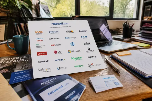 Affiche avec liste des marques rezoactif.com sur un bureau avec ordinateur et carnet ouvert