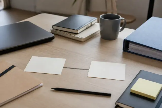 Deux cartes sur un bureau, l’une intitulée micro-entreprise, l’autre auto-entrepreneur, reliées par un trait au crayon