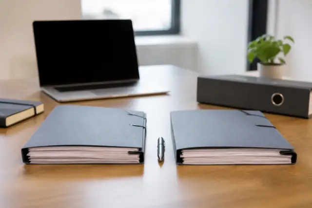 Deux dossiers de statuts côte à côte sur un bureau, l’un marqué EURL, l’autre SASU, un stylo entre eux
